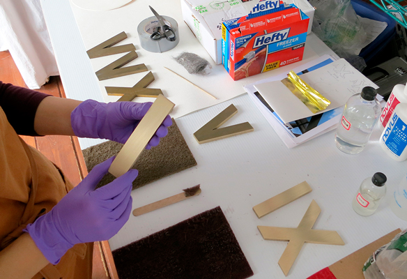 Laura Kubick restoring bronze numerals.