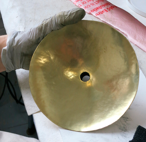 Susan Wood polishing parts of the clock.